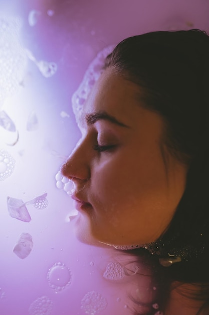 Close-up portrait of young woman in water