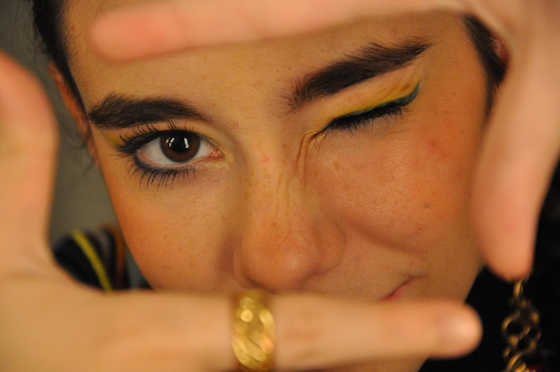 Photo close-up portrait of young woman winking while gesturing