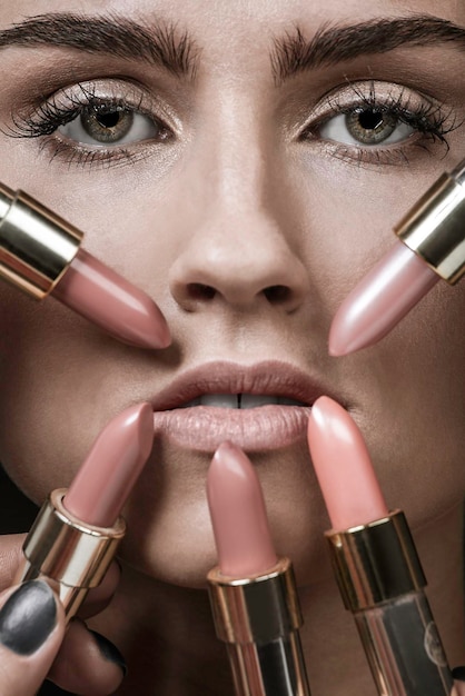 Photo close-up portrait of young woman with make-up and lipsticks