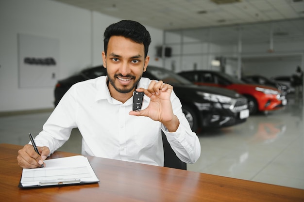 Close-up portret gelukkig lachende jonge man koper tonen sleutels van zijn nieuwe auto