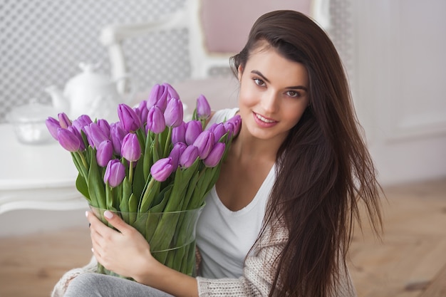 Foto close-up portret og zeer mooie jonge brunette vrouw met bloemen