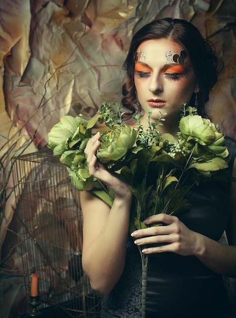 Close-up portret roodharige vrouw met heldere creatieve make-up met droge bloemen