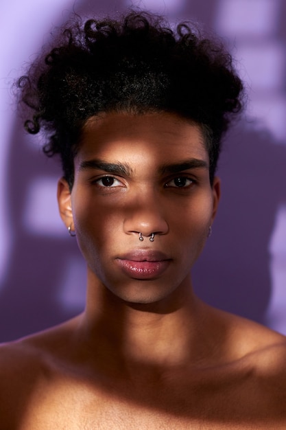 Close-up portret transgender jonge man kijken naar camera latino mannelijk model met naakte gespierde nek