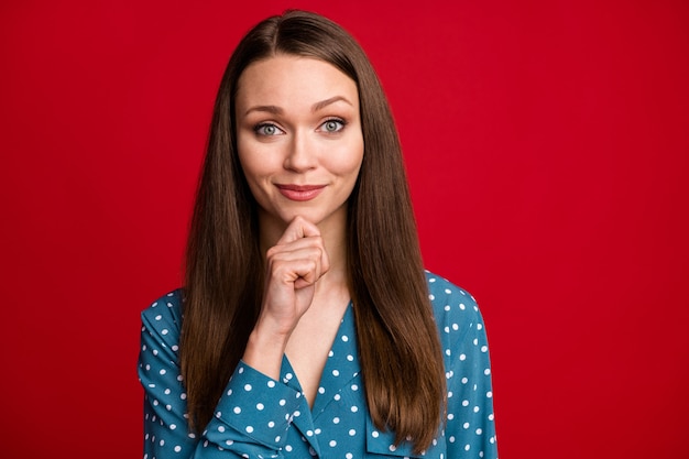 Close-up portret van aantrekkelijk intelligent slim vrolijk bruinharig meisje denken aan te raken kin geïsoleerde heldere rode kleur achtergrond