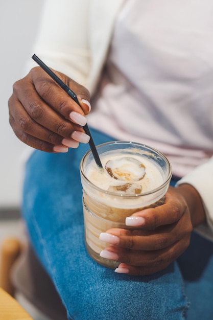 Close-up portret van de handen van de vrouw met glas ijskoffie met ijsblokjes Tasty Iced coffee Summer drinks