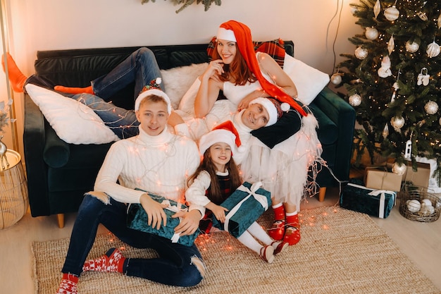 Close-up portret van een gelukkige familie zittend op een bank in de buurt van een kerstboom die een vakantie viert.