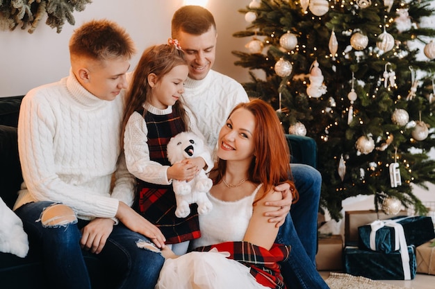 Close-up portret van een gelukkige familie zittend op een bank in de buurt van een kerstboom die een vakantie viert