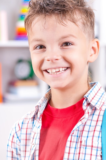 Close-up portret van een gelukkige glimlachende jonge jongen die naar de camera kijkt Kind in de klas of thuis