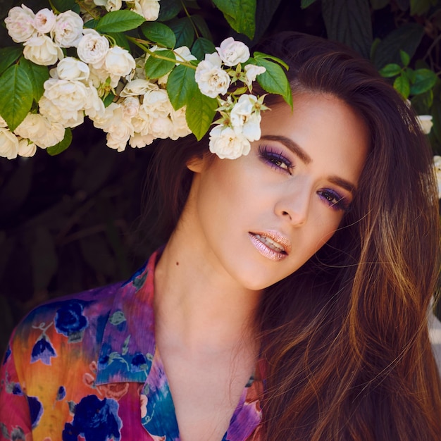 Close-up portret van een glimlachende jonge vrouw die bij planten staat
