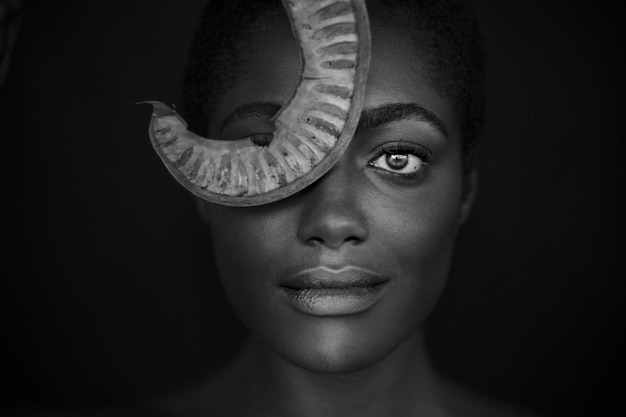 Foto close-up portret van een glimlachende jonge vrouw op een zwarte achtergrond