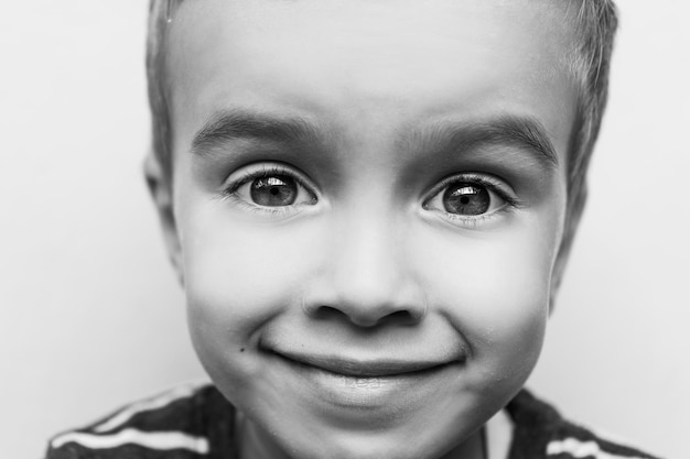 Foto close-up portret van een glimlachende jongen op een witte achtergrond