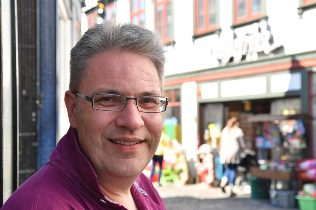 Foto close-up portret van een glimlachende man met een bril in de stad