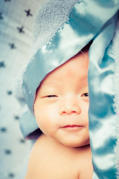 Foto close-up portret van een hemdloze baby die op het bed ligt