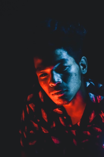 Close-up portret van een jonge man tegen een zwarte achtergrond