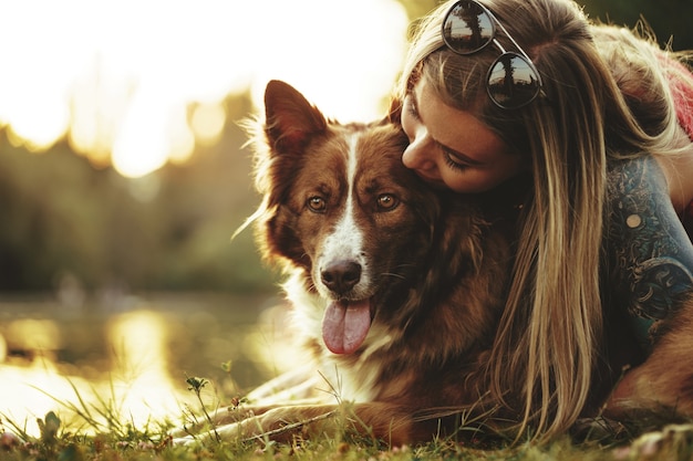 Close-up portret van een jonge vrouw die haar hond kust in het park