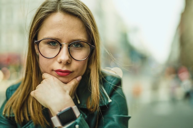 Close-up portret van een jonge vrouw die in de stad zit