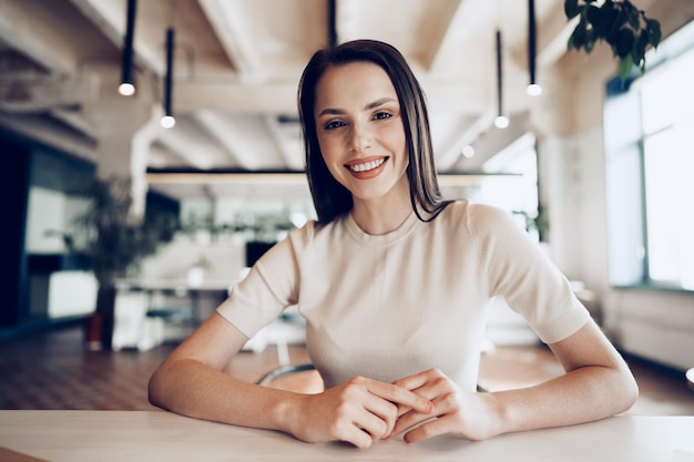 Close-up portret van een jonge vrouw die op kantoor aan tafel werkt