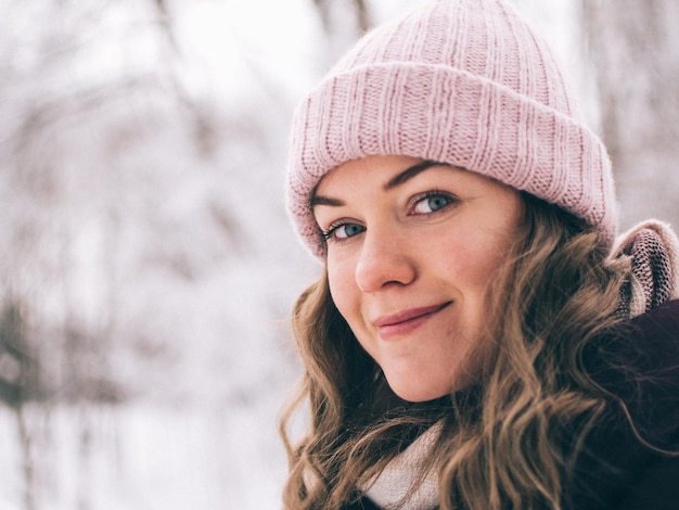 Close-up portret van een jonge vrouw met een gebreide hoed