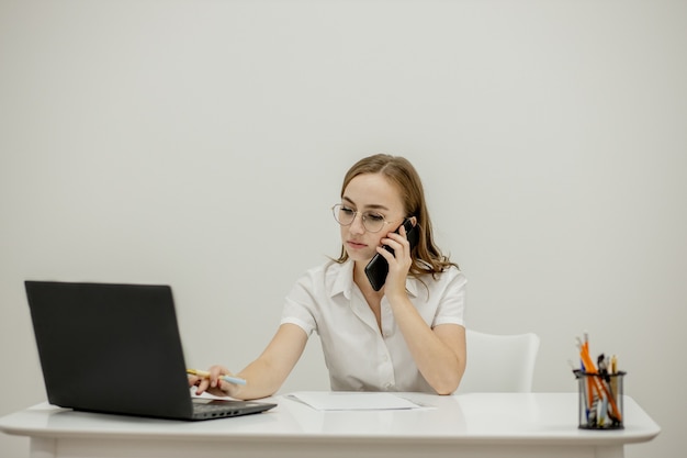 Close-up portret van een jonge zelfverzekerde vrouwelijke officemanager op haar werkplek, klaar voor zakelijke taak.