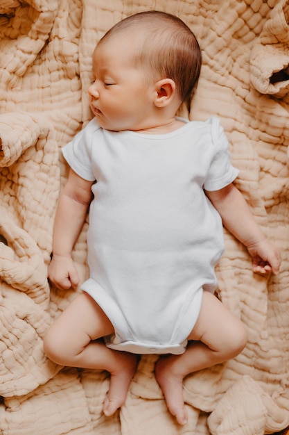 Close-up portret van een klein kind op het bed in haar kamer Schattige baby ligt op deken