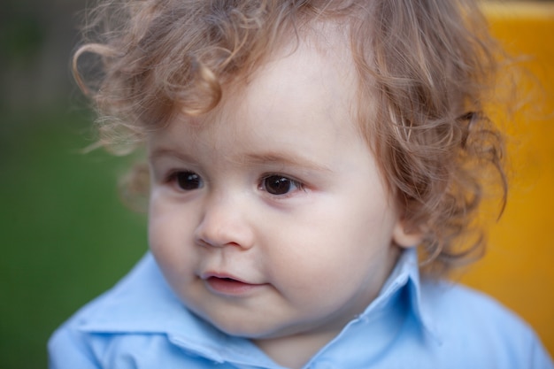 Close-up portret van een kleine blonde babyjongen. Grappig kindergezicht.