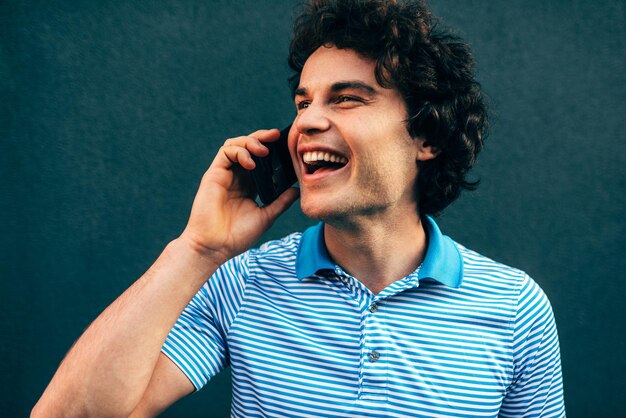 Close-up portret van een knappe jonge man die lacht en praat op de mobiele telefoon met zijn vriendin