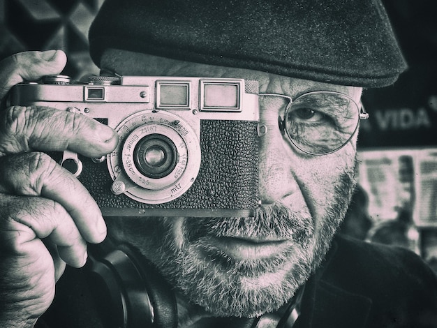 Close-up portret van een man die met een camera fotografeert