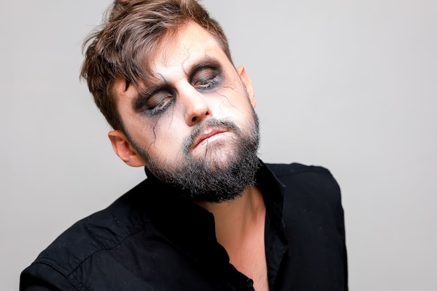 Close-up portret van een man met een baard met make-up voor Halloween in de stijl van de ondoden