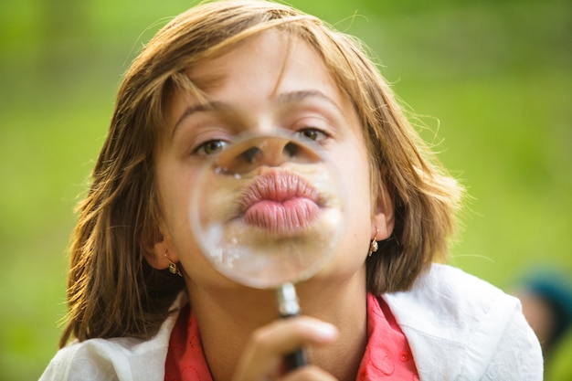 Close-up portret van een meisje dat speelt met vergrootglas