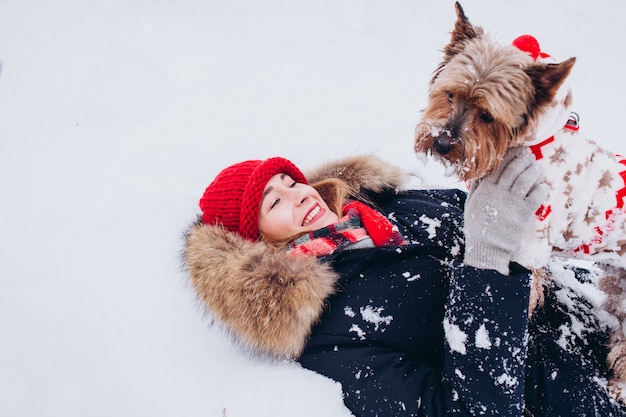 Close-up portret van een meisje met een hond in het winter woud, meisje in een rode gebreide muts