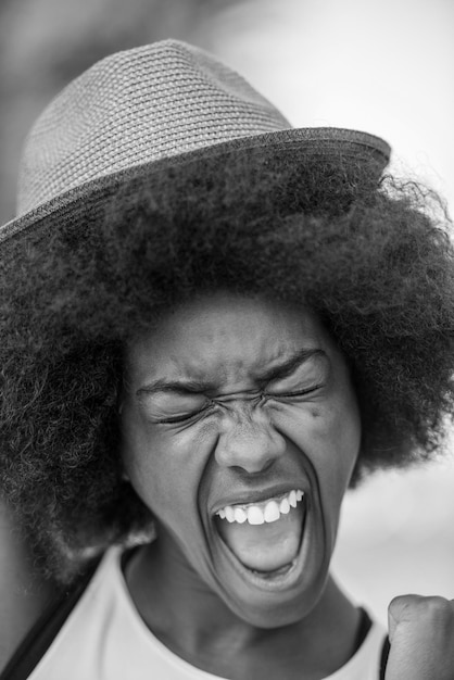 Close-up portret van een mooie jonge Afro-Amerikaanse vrouw die lacht en opkijkt op een mooie zonnige dag