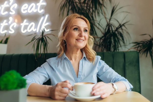 Close-up portret van een mooie vrouw van middelbare leeftijd met kopje koffie Rijpe vrouw 50s