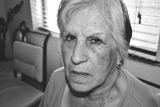 Foto close-up portret van een oudere vrouw bij het raam thuis