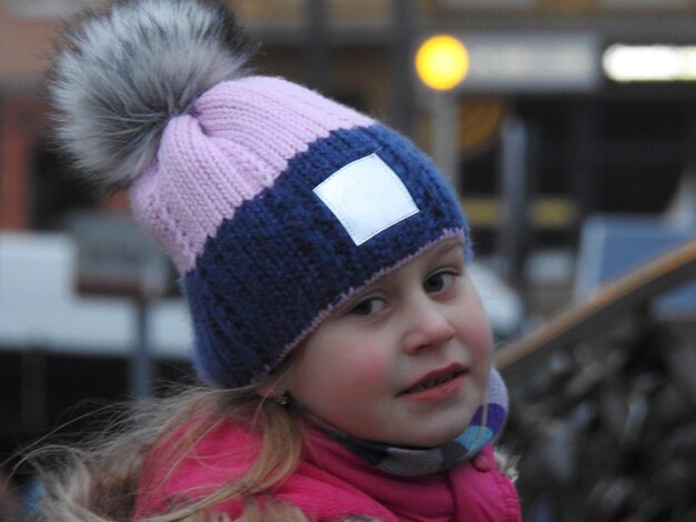 Foto close-up portret van een schattig meisje met een gebreide hoed