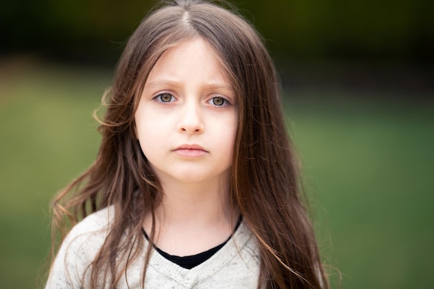Close-up portret van een schattig meisje met hazelroze ogen in het park