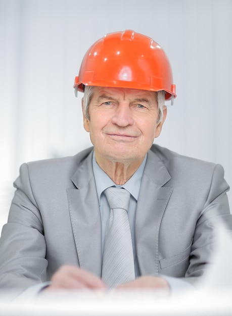 Close-up portret van een senior ingenieur die aan zijn bureau zit