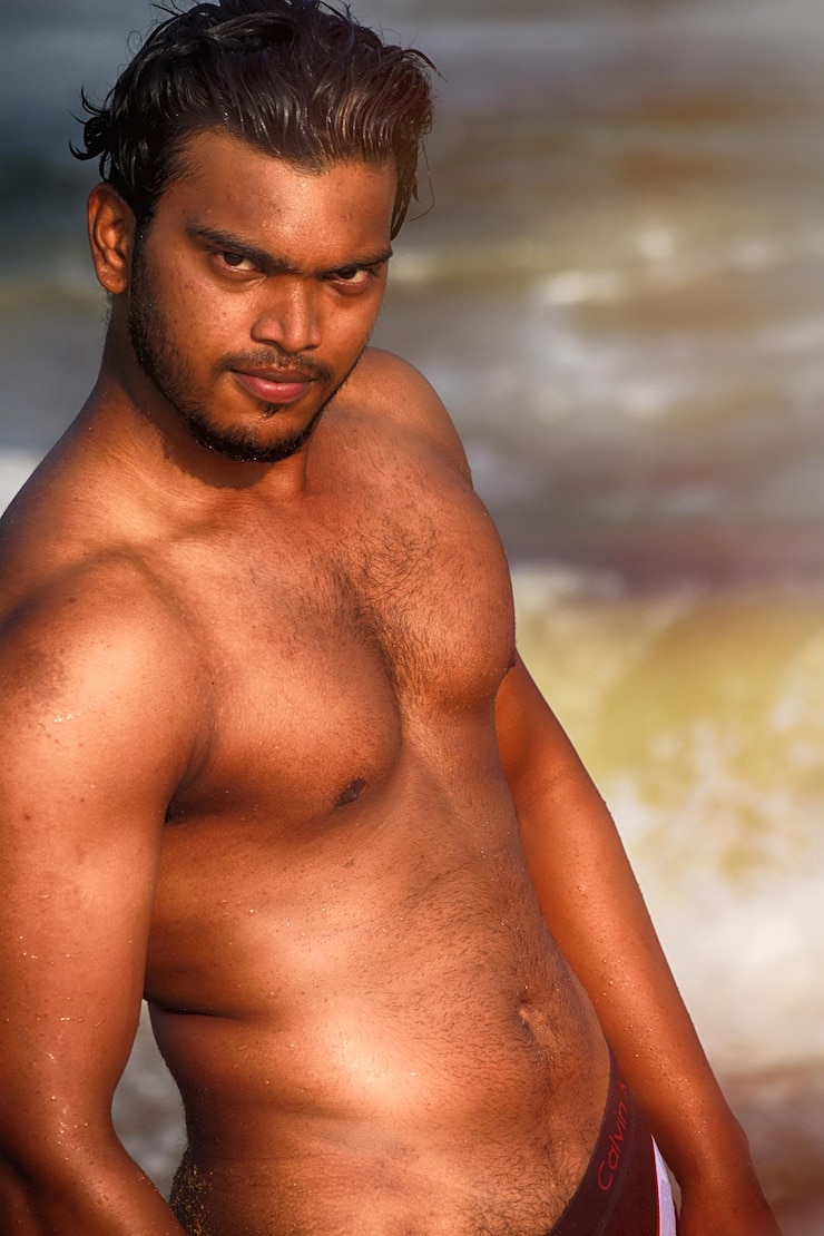 Foto close-up portret van een shirtloze man die op het strand staat