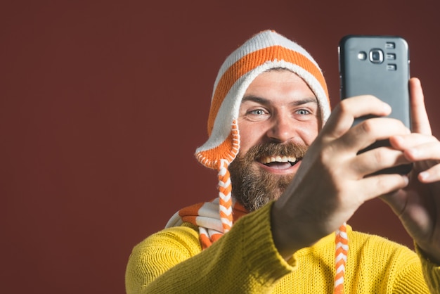 Close-up portret van een vrolijke bebaarde man selfie te nemen. Man zit en maakt selfie.