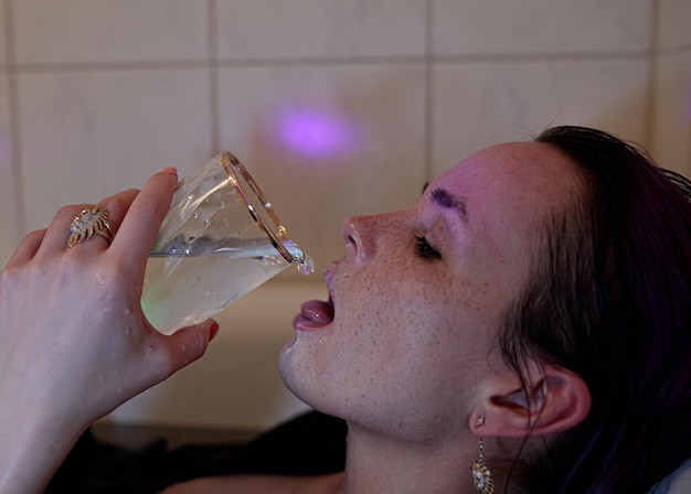 Foto close-up portret van een vrouw die glas drinkt.