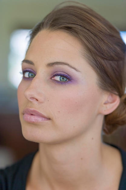 Foto close-up portret van een vrouw die thuis oogmake-up draagt