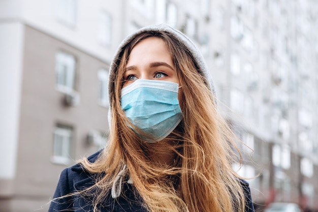 Close-up portret van een vrouw in een medisch masker op straat, epidemie van een coronavirus. vrouw schond de regels van zelfisolatie. sars-cov-2. bescherm uzelf tegen covid-19.