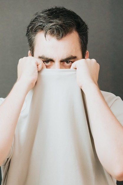 Close-up portret van gezonde man met baard en zwart haar sterke gelaatstrekken op zoek naar straightsad en depressieve jongeman gevoel overstuur Menselijke uitdrukkingen en negatieve emotiespersoonlijkheidspsychologie