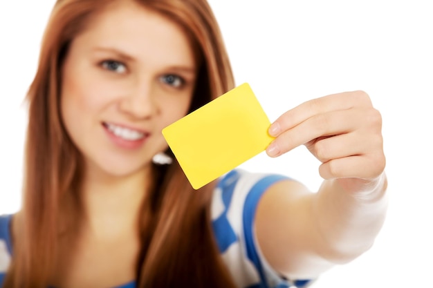 Foto close-up portret van glimlachende jonge vrouw met een blanco gele kaart