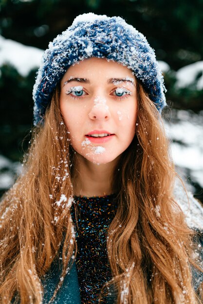 close-up portret van grappige en jonge langharige brunette met sneeuw over haar gezicht