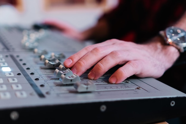 Close-up portret van handen bezig met sound mixer console voor het opnemen van uitzendingen of muziekproductie Ingenieur met behulp van studio Audio Mixer Knoppen en Faders Audio Concept