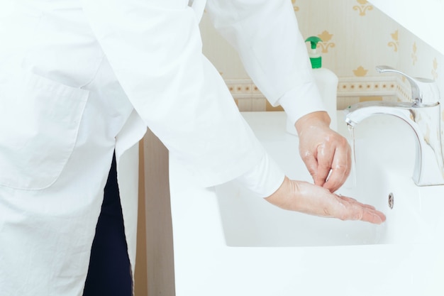 Close-up portret van handen wassen in de badkamer om virusoverdracht te voorkomen