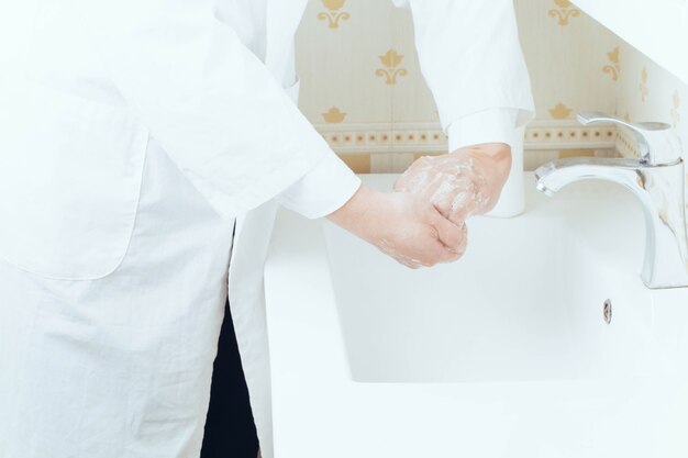 Close-up portret van handen wassen in de badkamer om virusoverdracht te voorkomen