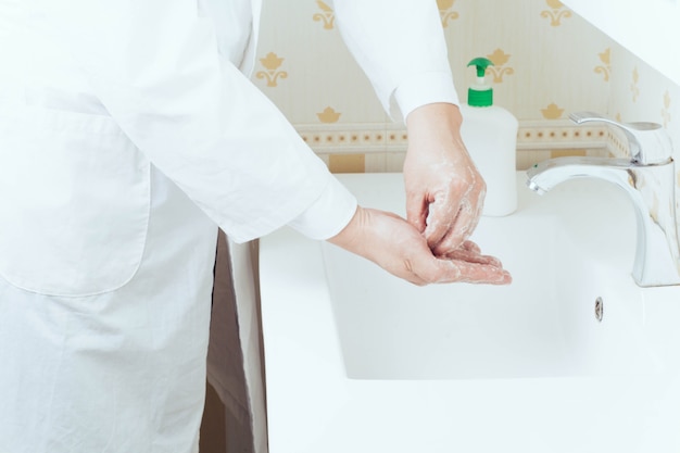 Close-up portret van handen wassen in de badkamer om virusoverdracht te voorkomen