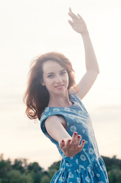 Close-up portret van jonge mooie gember harige vrouw dansen blauwe ogen en kleding zonsondergang l