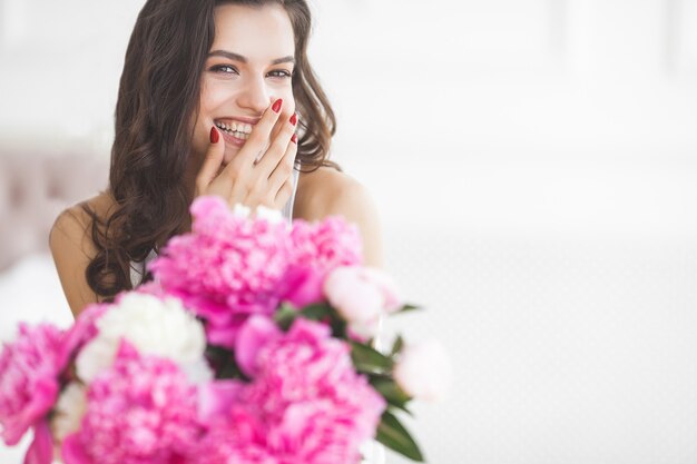 Close-up portret van jonge mooie vrouw met bloemen binnenshuis